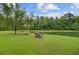 Picturesque backyard featuring a tranquil pond, comfortable seating, and a lush lawn under a blue sky at 249 Old Savannah Dr, Goose Creek, SC 29445