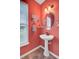 The powder room features an oval mirror, pedestal sink, and a window at 249 Old Savannah Dr, Goose Creek, SC 29445
