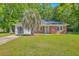Charming brick home with a lush green lawn and a mature palm tree in the front yard at 2736 Shadow Ln, North Charleston, SC 29406