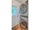 A laundry area featuring a stacked washer and dryer unit near a door and window at 2736 Shadow Ln, North Charleston, SC 29406