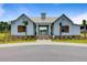Beautiful white clubhouse with a metal roof, surrounded by well maintained landscaping at 291 Calm Water Way, Summerville, SC 29486