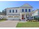 Charming two-story home featuring a red door, well-manicured lawn and a two-car garage at 291 Calm Water Way, Summerville, SC 29486