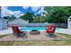 Outdoor seating area with a brick fire pit next to the pool, great for entertaining guests in your new home at 302 Axeminster Ct, Goose Creek, SC 29445