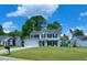 Traditional two-story home featuring a manicured lawn, attached garage, and charming curb appeal under a blue sky at 302 Axeminster Ct, Goose Creek, SC 29445