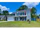 Well-kept two story home with mature landscaping, American flag, and desirable curb appeal on a sunny day at 302 Axeminster Ct, Goose Creek, SC 29445