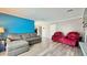 Bright living room featuring a gray sectional couch and two red cushioned armchairs at 302 Axeminster Ct, Goose Creek, SC 29445