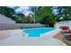 Inviting in-ground pool surrounded by a concrete patio, privacy fence, and lush landscaping for a relaxing outdoor oasis at 302 Axeminster Ct, Goose Creek, SC 29445