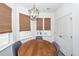 Bright dining area with wood table, three gray chairs, and a modern chandelier at 305 Flowering Peach Ct # 202, Charleston, SC 29414