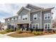 Charming gray two-story home with covered porch and rocking chairs offering curb appeal at 305 Flowering Peach Ct # 202, Charleston, SC 29414