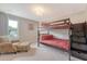 Bright bedroom featuring a bunk bed, cozy armchair, and natural light from a large window at 3173 Hugh Bennett Dr, Johns Island, SC 29455