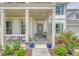 Inviting front porch with plants, seating, and a decorative wreath on the gray front door at 3173 Hugh Bennett Dr, Johns Island, SC 29455