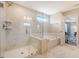 This luxurious main bathroom features a glass shower, soaking tub, and marble tile at 3173 Hugh Bennett Dr, Johns Island, SC 29455
