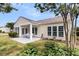 Backyard view featuring a covered patio with seating, a well-maintained lawn, and ample windows at 318 Oyster Bay Dr, Summerville, SC 29486