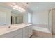 Bright bathroom featuring a double vanity, a soaking tub, and a glass-enclosed shower stall at 321 Bounty Ln, Charleston, SC 29412