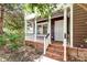 Inviting front porch with brick steps, classic white columns and railings and a vibrant green shrubbery at 321 Bounty Ln, Charleston, SC 29412