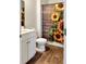 Clean bathroom with a white vanity featuring dual sinks, stylish flooring, and sunflower shower curtain at 323 Bear Paw Ln, Summerville, SC 29486
