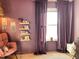 Charming bedroom with purple walls, a cozy rocking chair, decorative shelving, and window with plush curtains at 323 Bear Paw Ln, Summerville, SC 29486