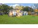 Lush backyard showcasing a manicured lawn, shade trees, and a charming house elevation bathed in warm sunlight at 33 Elliott Ct, Walterboro, SC 29488