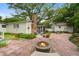 Expansive backyard featuring a fire pit, guest house, mature trees, and a brick patio at 344 Lantana Dr, Charleston, SC 29407
