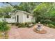 Secluded backyard featuring a brick patio, a guest house, mature landscaping, and a tranquil fountain at 344 Lantana Dr, Charleston, SC 29407