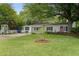Charming single-story home featuring a lush green lawn, mature trees, and a quaint front porch at 344 Lantana Dr, Charleston, SC 29407