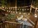 Night view of a backyard brick patio with table, chairs, a wood burning fire pit, and string lights at 3738 Station Point Ct, Mount Pleasant, SC 29466