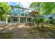 Beautiful backyard of a light blue raised beach house with a deck, pergola, and patio area with outdoor furniture at 3738 Station Point Ct, Mount Pleasant, SC 29466