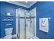 Stylish bathroom with tiled shower, blue walls, and decorative shelving for a modern touch at 3738 Station Point Ct, Mount Pleasant, SC 29466