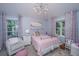 Cozy bedroom with modern chandelier, two windows, and white metal bed frame at 3738 Station Point Ct, Mount Pleasant, SC 29466