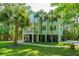 Coastal home with garage and double balconies amid palm trees, offers a breezy, relaxed island living experience at 3738 Station Point Ct, Mount Pleasant, SC 29466