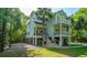 Stylish two-story home featuring double balconies, set amidst lush trees, evoking a tranquil, seaside atmosphere at 3738 Station Point Ct, Mount Pleasant, SC 29466