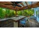 Outdoor bar area under a pergola, featuring a ceiling fan, lighting, and barstool seating at 3738 Station Point Ct, Mount Pleasant, SC 29466