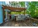 Spacious outdoor kitchen on a wood deck, equipped with a grill, bar seating, and wood pergola at 3738 Station Point Ct, Mount Pleasant, SC 29466