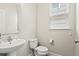 Powder room with pedestal sink, toilet, and window at 3901 Poplar Grove Pl, Summerville, SC 29483