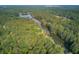 A tranquil river lined with green trees reflects the sky in this serene aerial landscape at 4292 Cloudmont Dr, Hollywood, SC 29449