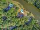 Aerial view of a home with a sparkling blue pool, nestled among trees near a tranquil lake at 4292 Cloudmont Dr, Hollywood, SC 29449