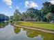 A serene lakefront home features lush landscaping and a private waterfront and dock at 4292 Cloudmont Dr, Hollywood, SC 29449