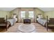 Bright bedroom featuring two twin beds, hardwood floors, and bright windows at 4292 Cloudmont Dr, Hollywood, SC 29449