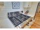 Close up of the gas range cooktop and stainless steel hood with a white backsplash at 4292 Cloudmont Dr, Hollywood, SC 29449