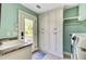 Bright laundry room with storage cabinets, sink, and door to outside at 4292 Cloudmont Dr, Hollywood, SC 29449