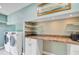 Functional laundry room with appliances, counter space, and shelving offers convenience and organization at 4292 Cloudmont Dr, Hollywood, SC 29449