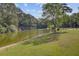 Scenic view of the waterfront featuring a sandy beach and lush green lawn at 4292 Cloudmont Dr, Hollywood, SC 29449