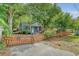 A quaint home with a picket fence and inviting gated driveway, nestled under mature trees, offering privacy at 4546 Holly St, North Charleston, SC 29405