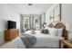 Bright bedroom featuring large bed with decorative pillows, side tables, flat-screen TV, and large windows at 4557 Mixson Ave, North Charleston, SC 29405