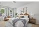 Cozy bedroom featuring a king bed with throw blanket, bedside tables, couch, and bright windows at 4557 Mixson Ave, North Charleston, SC 29405
