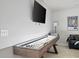 Game room features a shuffleboard table with light, mounted TV, a movie poster, and a comfy sofa at 4557 Mixson Ave, North Charleston, SC 29405