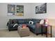Inviting living room features a comfortable blue sofa, movie posters, a modern lamp, and neutral carpet at 4557 Mixson Ave, North Charleston, SC 29405