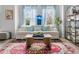 Well-lit living room boasts a cozy sofa, colorful rug, and large windows with light blue curtains at 4557 Mixson Ave, North Charleston, SC 29405