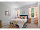Bedroom features a blue headboard, colorful pillows and curtains, and patterned carpet at 4585 Summey St, North Charleston, SC 29405