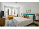 Bright bedroom features a blue accent headboard, white bedding, hardwood floors and a yellow sofa at 4585 Summey St, North Charleston, SC 29405